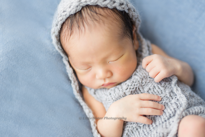 洋服を着たニューボーンべビーが寝ている